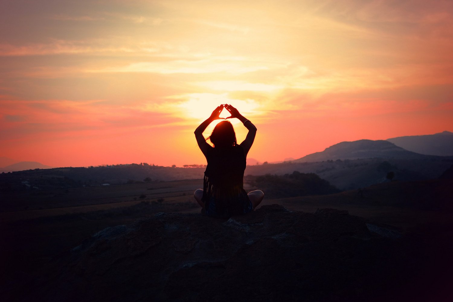 Silhouette of a person in a mindful pose at sunset