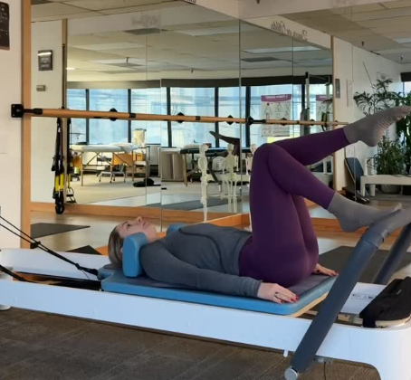 Client on a Pilates reformer machine during a session at E-Motion